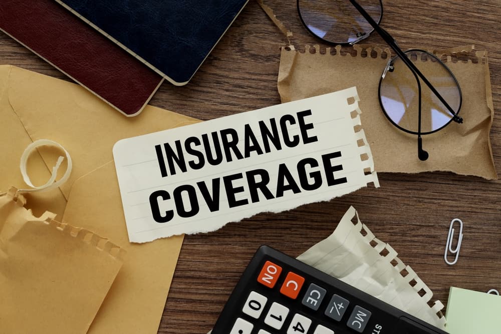 Insurance coverage text on torn paper on the background of different stationery