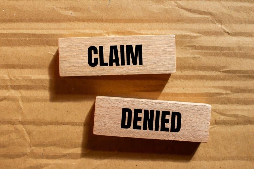 Claim Denied written on wooden piece