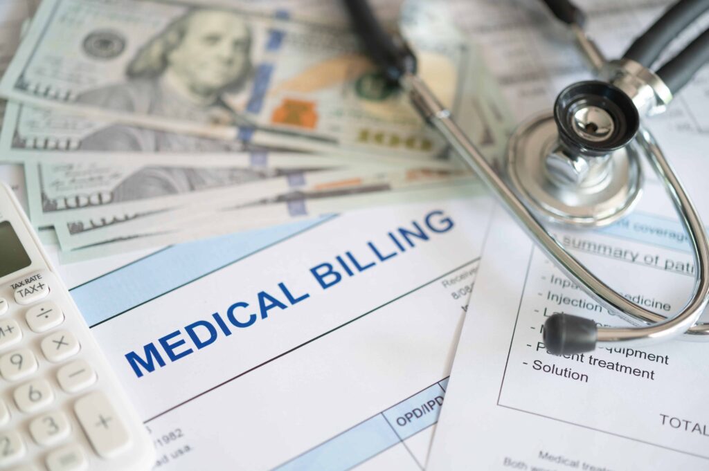 Medical billing documents with stethoscope, calculator, and cash representing healthcare costs.