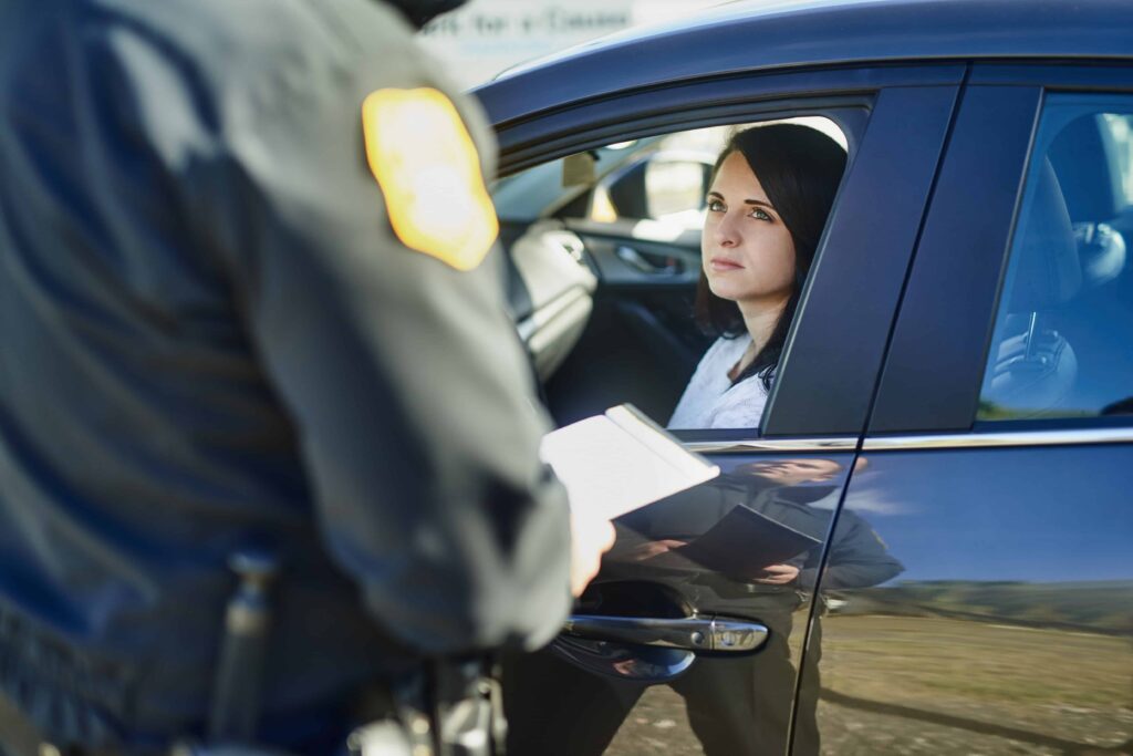 Driver speaking with police officer during a traffic stop. Driver speaking with police officer during a traffic stop.